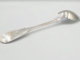 une cuillère en argent avec un manche de cuillère sur une surface blanche