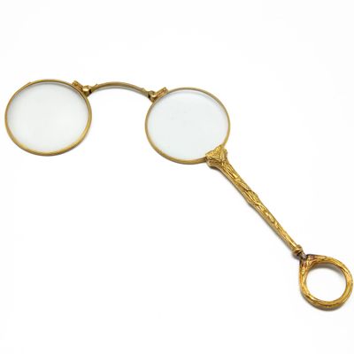 pair of gold plated magnifying glasses on a white background