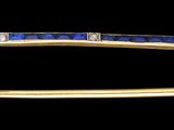 une image représentant une broche en or ornée de pierres bleues