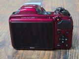 a red digital camera sitting on a wooden table