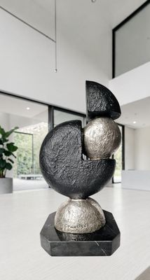 une sculpture noire et argentée posée sur une table dans une pièce