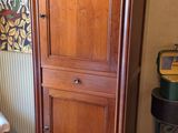 une grande armoire en bois dans un coin du salon
