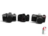 two old cameras are sitting next to each other on a white surface