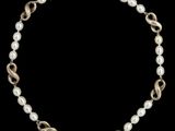 un collier en or et perles sur fond noir