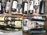 several bottles of wine are in a cardboard box on the floor
