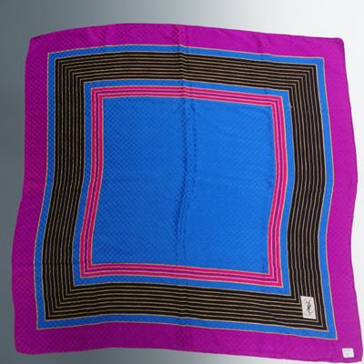 un gros plan sur une écharpe carrée violette et bleue posée sur une table