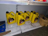 five bottles of motor oil sitting on a shelf in a garage