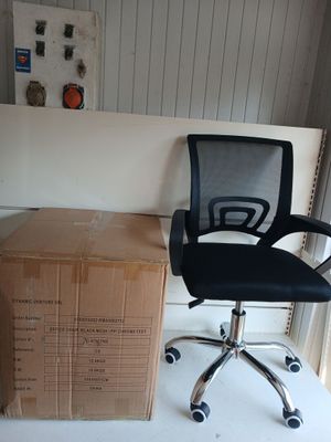 a black office chair sitting next to a stack of boxes