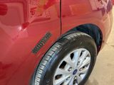 a close up of a red car with a sticker on it
