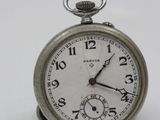a silver pocket watch sitting on a white surface