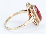 a close up of a red stone ring on a white background