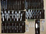 a picture of a collection of silverware and utensils laid out on a table