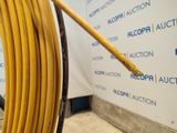 a large yellow hose that is next to a wall