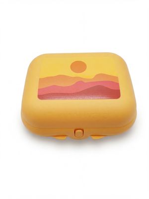 une petite boîte jaune sur laquelle est représenté un coucher de soleil