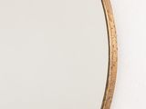 a close up of a mirror hanging on a wall next to a white wall