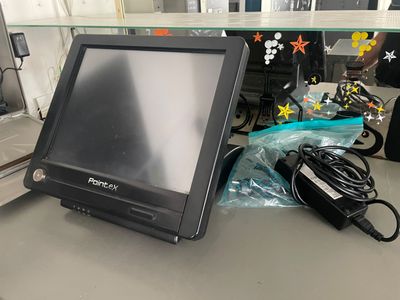 un écran d'ordinateur posé sur un bureau, avec un chargeur