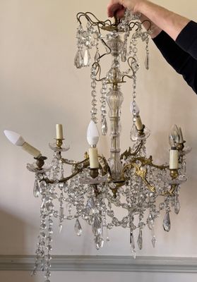 a woman that is holding a chandelier in her hand