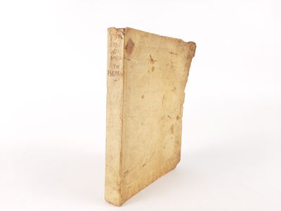 an old book sitting on top of a white table next to a white wall