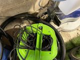 a green blower and a blue vacuum on the ground