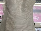 a wedding dress hanging on a hanger in front of a window