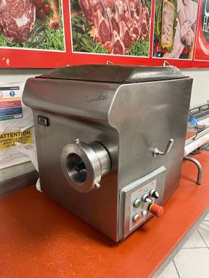 an image of a meat grinder sitting on a counter in a restaurant