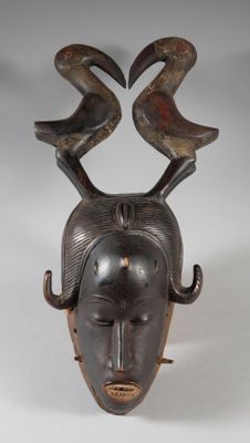 une image représentant un masque en bois orné de cornes sur la tête