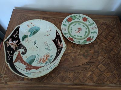 two plates and a bowl sitting on a wooden table