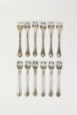 eight silverplated forks and spoons on a white surface