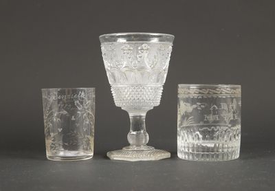 trois verres et un gobelet en verre posés sur une table
