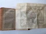 an open book with a map of asia on it sitting on a table