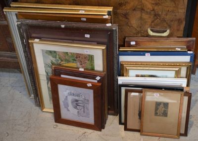 de nombreuses œuvres d'art encadrées posées par terre à côté d'une commode