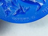 a close up of a blue plate with a dolphin on it