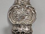 un plat en argent finement décoré, orné d'une croix et d'un oiseau
