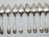 six spoons are lined up in a row on a white surface