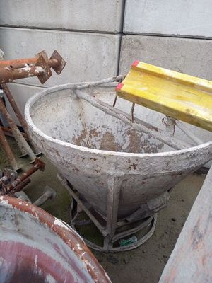 a large metal bowl sitting next to a rusty pipe