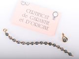 a necklace and a bracelet on a table with a certificate