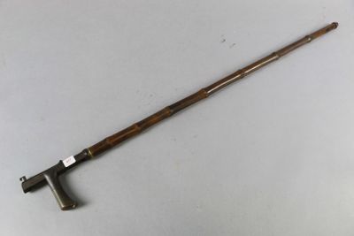 a close up of a wooden stick with a handle on a white surface