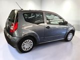 a small grey car parked in a white room