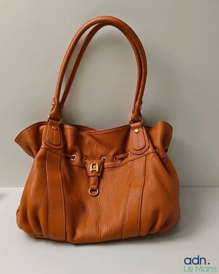 a brown purse sitting on top of a white table