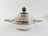 a silver dish with a pine on top of it