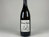 une bouteille de vin posée sur une table blanche