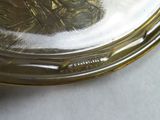 a silver plate on a white table with a silver lid