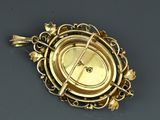 an image of a gold broochle with a clock on it