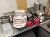 many plates and cups on the counter in the kitchen