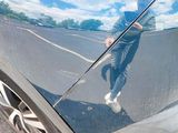 a reflection of a person on the side of a car