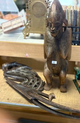 a statue of a cat sitting on a shelf next to other items