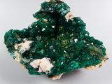 a close up of a cluster of green crystals on a white surface