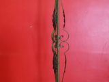 an antique floor lamp stands in front of a red wall