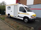 un camion blanc orné d'une bande jaune, garé devant un immeuble