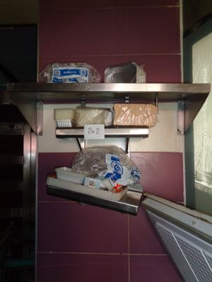 un réfrigérateur dans un coin d'une cuisine, dont les étagères sont bien remplies de nourriture